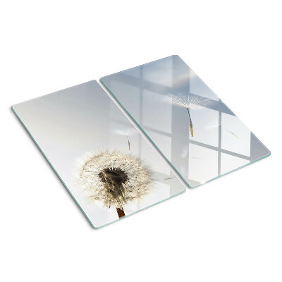 Glazen snijplanken Paardenbloemen op de achtergrond van het raam