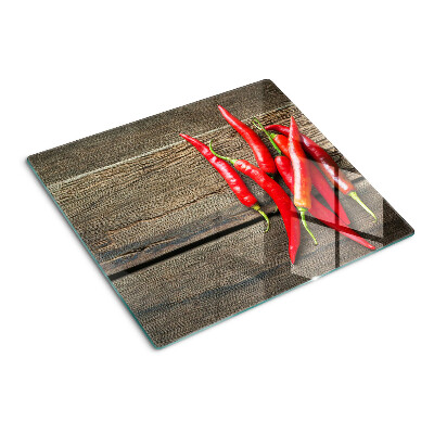 Glazen snijplanken Chilipepers op een houten achtergrond