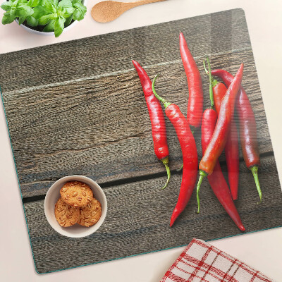 Glazen snijplanken Chilipepers op een houten achtergrond