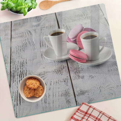 Glazen snijplanken Koffie en macarons op een houten achtergrond