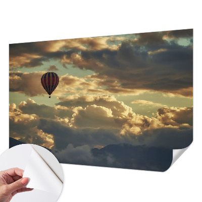 Fotobehang babykamer met een print van een ballon tussen de wolken