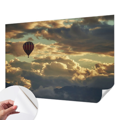 Fotobehang babykamer met een print van een ballon tussen de wolken
