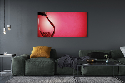 Canvas doek foto Rode achtergrond met een glas over