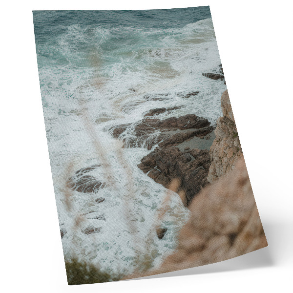 Wandposter Zeegolven en een rotsachtige kust in turquoise tinten