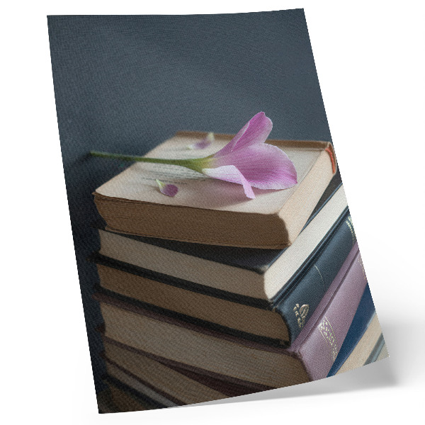 Poster Een stapel boeken met een tere bloem erop.