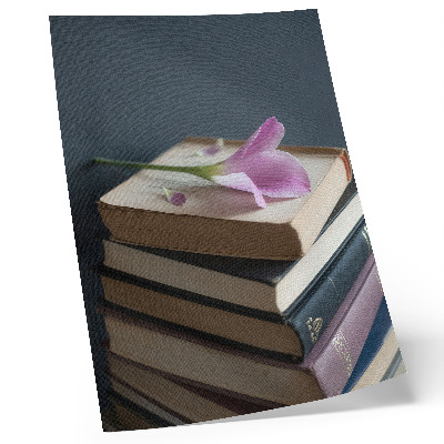 Poster Een stapel boeken met een tere bloem erop.