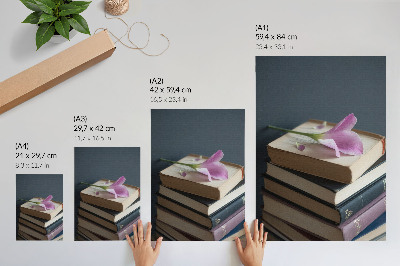 Poster Een stapel boeken met een tere bloem erop.