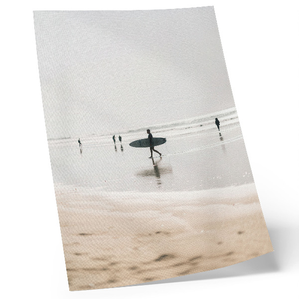 Poster Een surfer loopt over het strand met een surfplank.