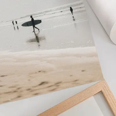 Poster een surfer die over het strand loopt met een surfplank