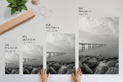 Wandposter Vreedzaam landschap, brug, rotsachtig strand, grijze lucht