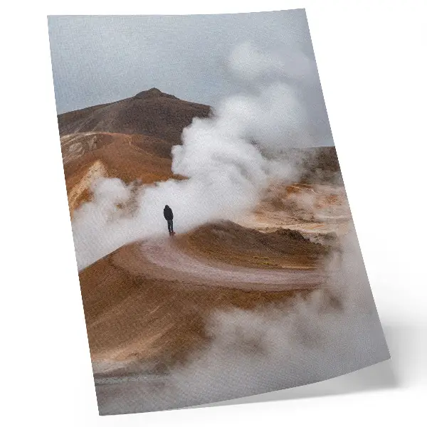 Wandposter bruine bergen met dampende mist en een eenzame zwerver in een landschap
