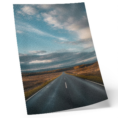 Poster Een weg door de herfstvlakte onder een blauwe hemel.