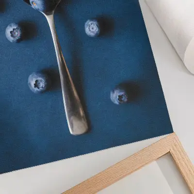 Poster bosbessen op een lepel op een blauwe achtergrond met een elegante uitstraling