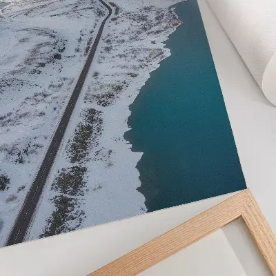 Poster met een besneeuwd landschap in een minimalistische stijl en blauw water