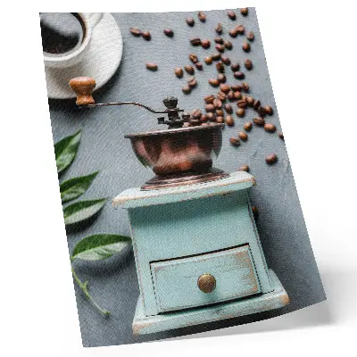 Decoratieve poster met een oude turquoise koffiemolen, koffiebonen en groene bladeren