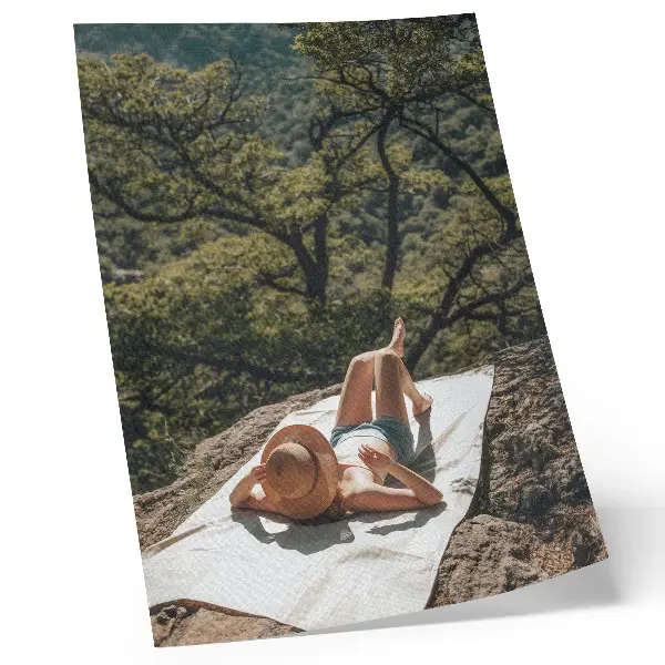 Decoratieve poster met een persoon ontspannend op een rots tussen groene bomen en een hoeddragend figuur in de natuur