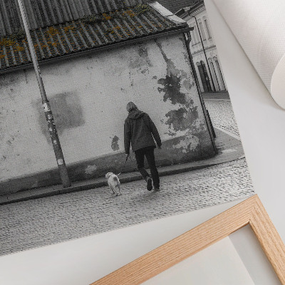 Wandposter Een persoon met een hond voor een oud gebouw.