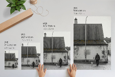 Wandposter Een persoon met een hond voor een oud gebouw.