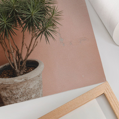 Decoratieve poster Groene plant tegen de achtergrond van een perzikkleurige muur
