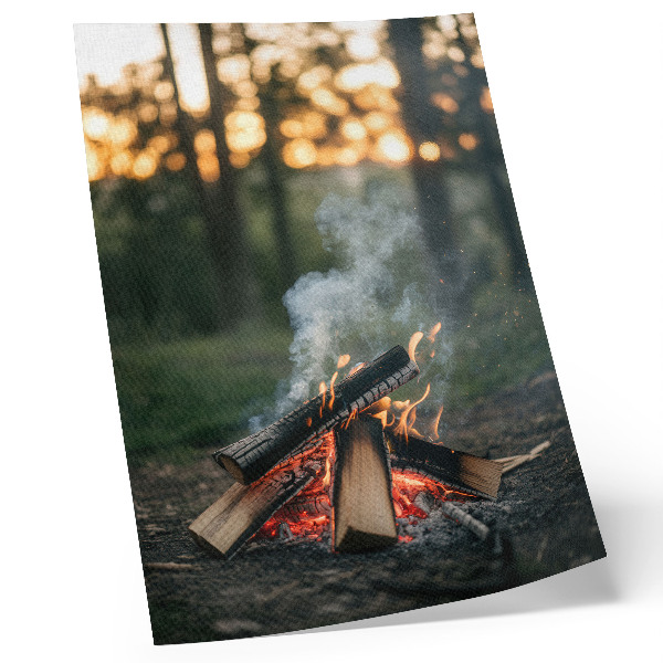 Wandposter Een kampvuur tegen de achtergrond van bos en rook.