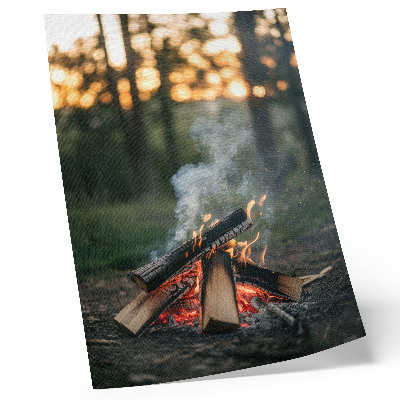 Wandposter Een kampvuur tegen de achtergrond van bos en rook.