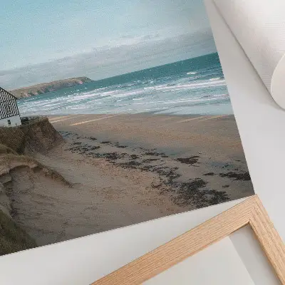 Poster met strand, golven en huis op een klif in pastelkleuren