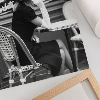 Poster een vrouw met een hoed aan een tafel in een café