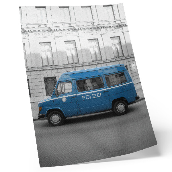 Poster Een blauwe politieauto met een gebouw op de achtergrond.