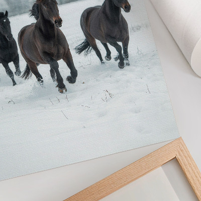 Wandposter Zwarte paarden in beweging tegen een besneeuwde achtergrond.