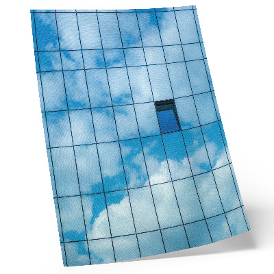 Wandposter Een glazen gevel die de lucht en wolken weerspiegelt.