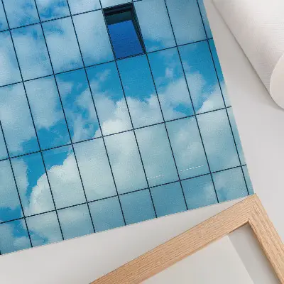 Wandposter met een reflectie van de lucht en wolken in een glazen gevel