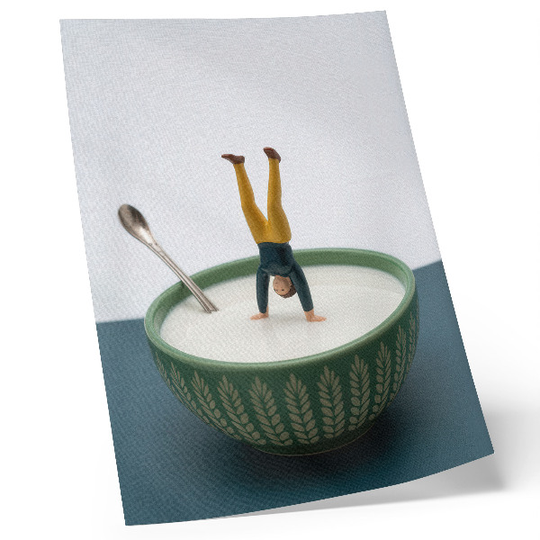 Wandposter Figuurtje in een kom melk met groene bladeren
