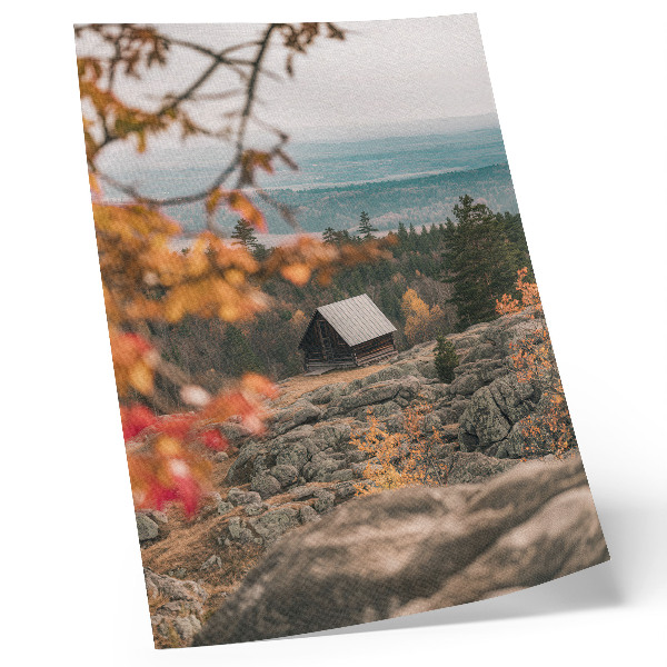 Wandposter Een huis op een rots tussen bomen in de herfst, vredige natuur.
