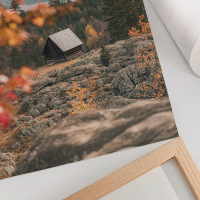 Wandposter Een huis op een rots tussen bomen in de herfst, vredige natuur.