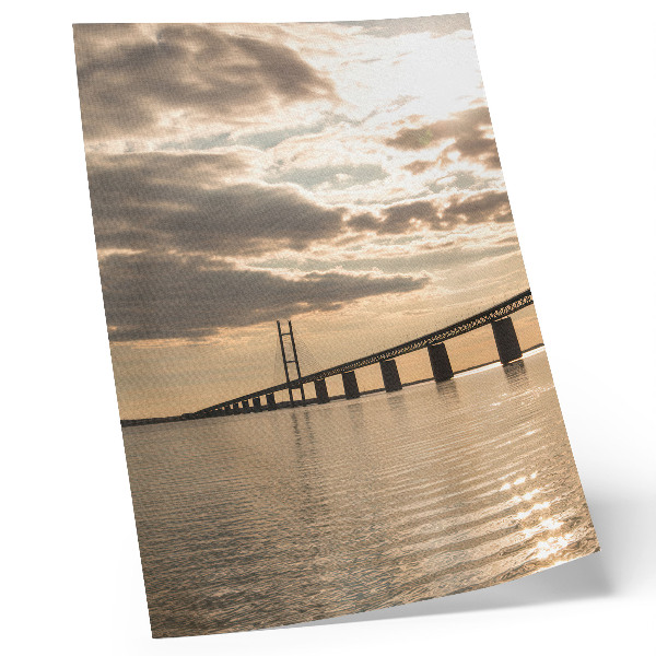 Poster Een brug over het water in het licht van de ondergaande zon.