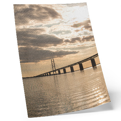 Poster Een brug over het water in het licht van de ondergaande zon.