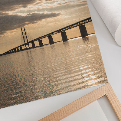 Poster Een brug over het water in het licht van de ondergaande zon.