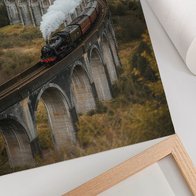 Poster Een trein op een brug tussen groene heuvels
