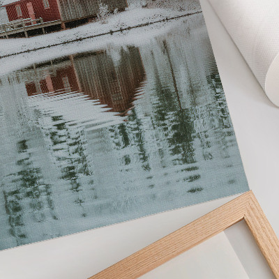 Wandposter Een rood huisje tussen besneeuwde bomen aan het water.