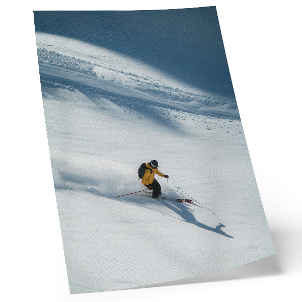 Poster Skiër met gele jas, sneeuw, helling, schaduw