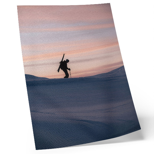 Poster Een skiër tegen een roze lucht in een winterlandschap