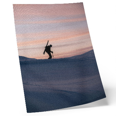 Poster Een skiër tegen een roze lucht in een winterlandschap