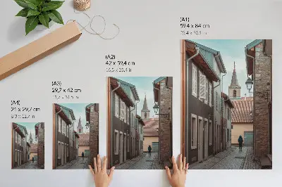 Wandposter smalle straat met huurkazernes, een toren en een persoon in een blauwe jas