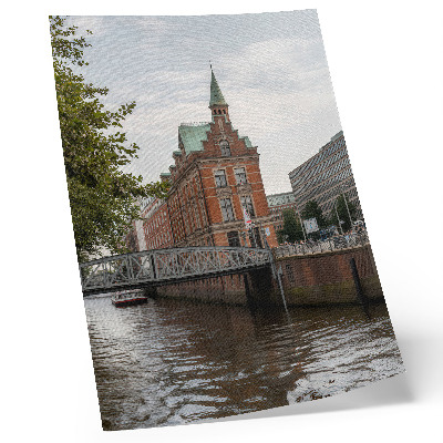 Poster Historisch gebouw met bakstenen gevel, rivierbrug en toren.