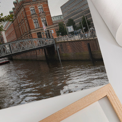 Poster Historisch gebouw met bakstenen gevel, rivierbrug en toren.