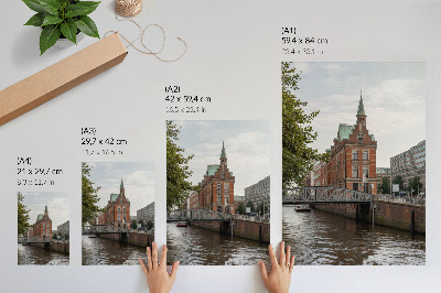 Poster Historisch gebouw met bakstenen gevel, rivierbrug en toren.