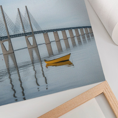 Poster Een brug tegen de hemel en het water met een gele boot.