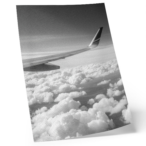 Poster Vliegtuigvleugel boven de wolken in zwart-witstijl