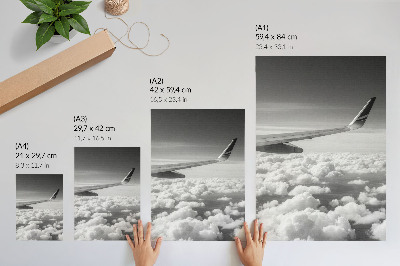 Poster Vliegtuigvleugel boven de wolken in zwart-witstijl