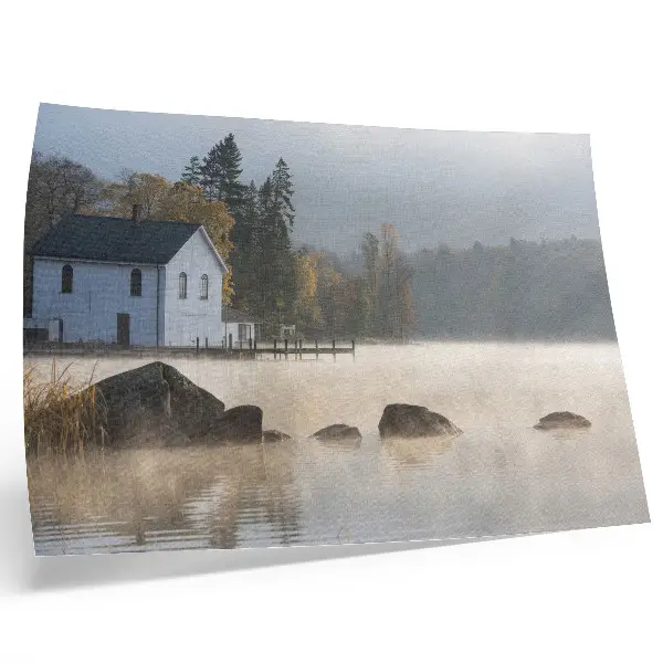 Stijlvolle wandposter met een mistig landschap van een meer met een huisje en bomen in herfstkleuren